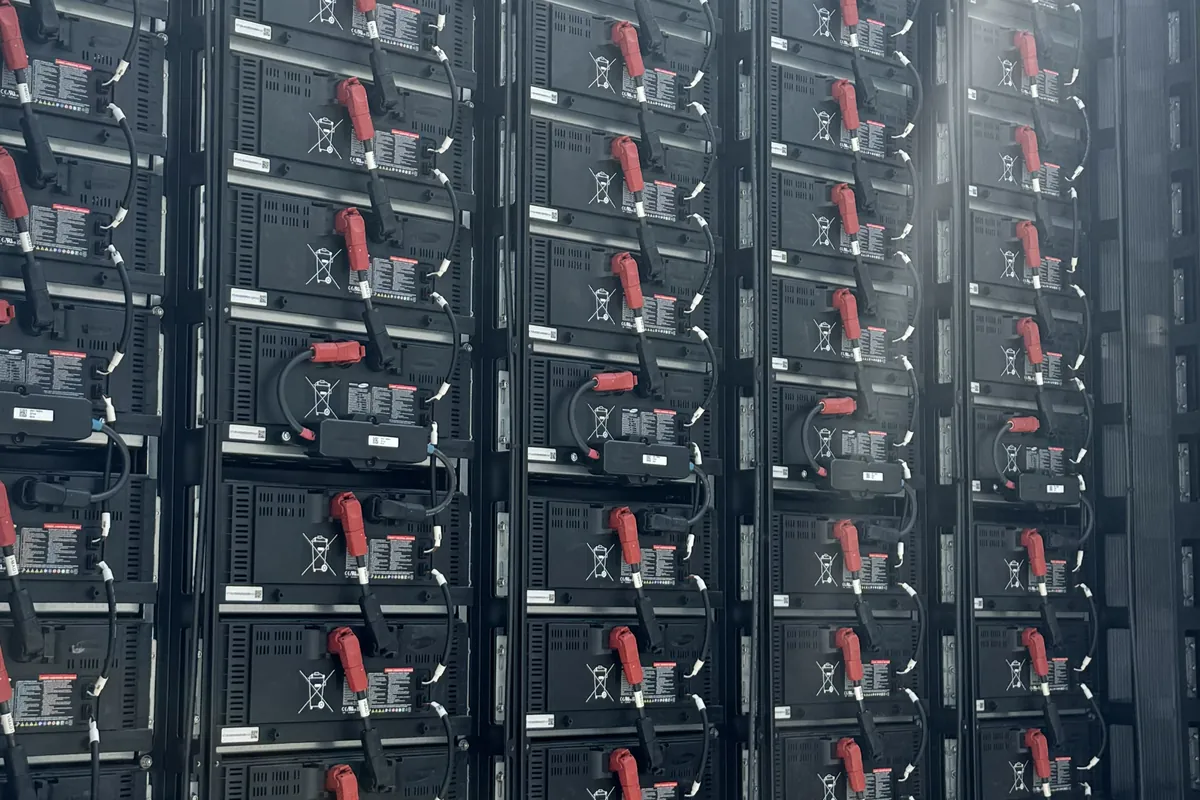 Interior de um módulo de armazenamento, com racks de baterias e cabeamento de potência